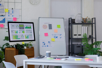 Laptop Computer, notebook ESG topic presentation on monitor, and eyeglasses sitting on a desk in a large open plan office space after working hours	