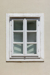 Obraz premium Window in white wooden frame set against a beige stucco wall, photo background