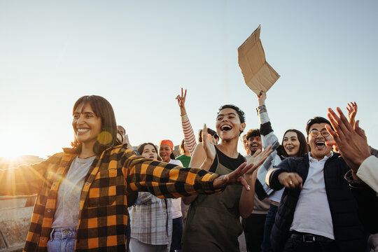Group of young adults expressing joy and support at a public gathering - Powered by Adobe