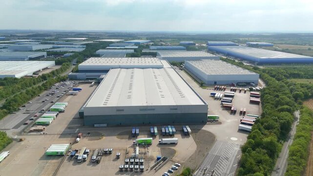 Lutterworth, United Kingdom - 09 August 2025: Aerial view of industrial buildings creating a symmetrical pattern, with trucks and cars adding color.