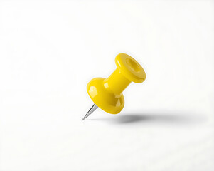 A yellow push pin with a flat head and metallic point is placed on a white background with reflections on a plastic surface.
