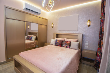 Interior design decor furnishing of luxury show home bedroom showing furniture and double bed with wardrobe