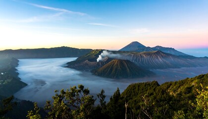 Fototapeta premium Volcanic landscape at sunrise, mist-filled caldera, mountains in background