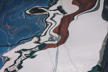 Reflections of intriguing shapes and colors blend harmoniously in a serene lakeside setting during early morning light
