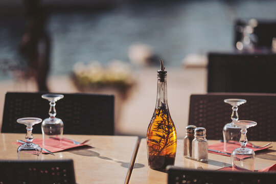 Charming outdoor dining setup on a sunlit terrace with an elegant bottle and glasses highlighting a relaxing afternoon by the waterfront