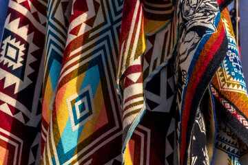 Hanging traditional andean ponchos on handicraft market of Otavalo, Ecuador. Designs can be found in Ecuador, Peru and Bolivia.