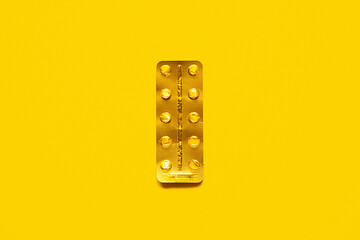 Used golden blister pack on yellow background.