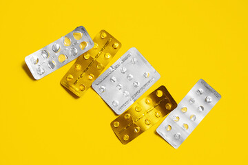 Empty medical blister pack without pills on bright yellow background.