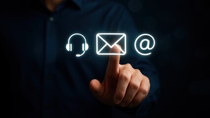 Businessman in blue shirt raising hand to touch glowing icons for email marketing in dark tech setting, email analytics and marketing automation concept