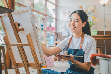 Art student drawing with watercolor painting on canvas doing some art projects on studio workshop