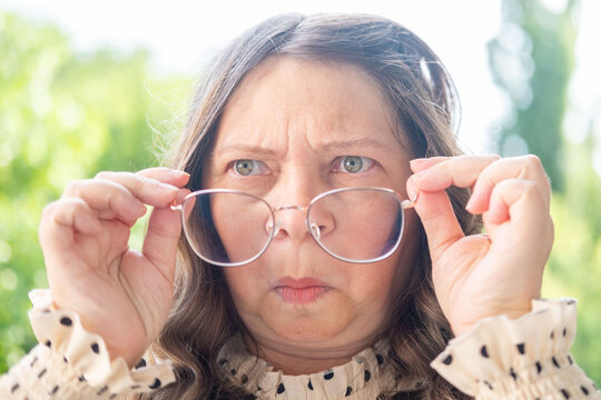 Mature woman 50 years old wearing glasses, poor vision, myopia problem, optical exam, diopter accuracy, female with eyeglasses, correct lens diopters, eyesight health, Emotional portrait, aging - Powered by Adobe