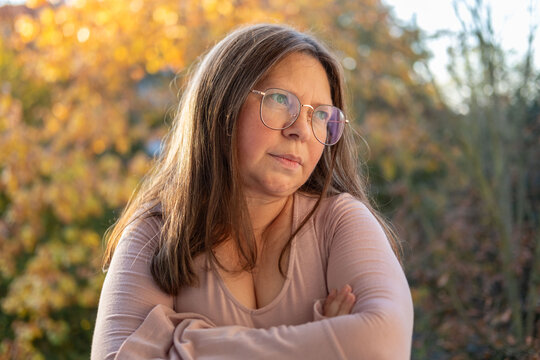 skeptical woman narrows eyes, expression filled with doubt in natural setting, raised eyebrow and tight lips convey skepticism in intimate nature portrait, unexpected doubts, mistrust