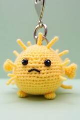 Obraz premium keychain of A chubby crochet pufferfish with light yellow yarn spikes and a surprised face.