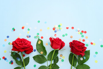 Top view image of red roses flowers composition over blue background .Flat lay