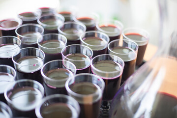 Wine in glasses on a tray. Plastic dishes on the table. A tray of wine.