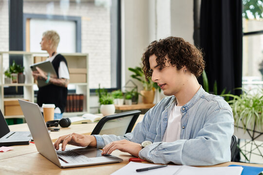 Focused youth engaged in an office task while colleagues collaborate nearby in a modern workspace