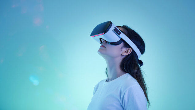 Metaverse technology concept, A young woman wearing a VR headset looks upwards, immersed in a digital world with a futuristic blue and green glow. - Powered by Adobe