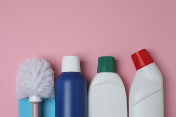 brush and cleaning container on a pink background
