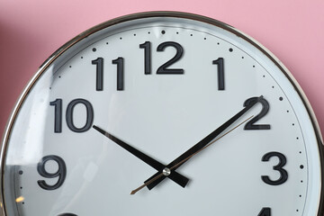 wall clock on a pink background
