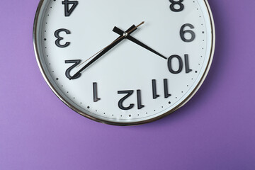 wall clock on purple background
