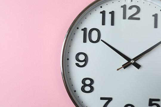 wall clock on a pink background
