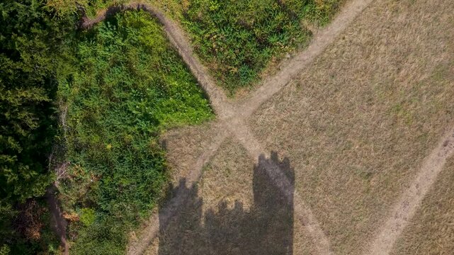 Aerial top-down drone shot above grass, showing shadows of Blaise Castle&rsquo;s turrets. As the drone pulls back, the historic castle emerges from the shadow.