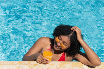Tourist enjoying summer vacation drinking juice in blue water