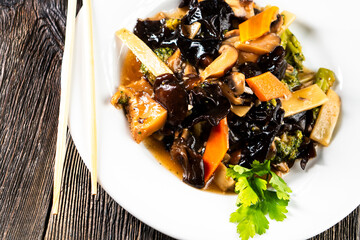 Chinese Mixed Vegetable Stir-Fry with Wood Ear Mushroom Black Fungus on dark background. Asian food. Chinese cuisine. Seafood. Vegetables