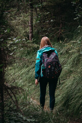 Woman walking along a trail in the Ötschergraben canyon, surrounded by rocks, trees, and steep...