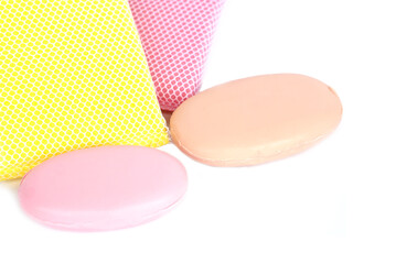 Colorful bath sponges with mesh texture and two oval soap bars placed on white background. Concept of body care, hygiene, spa, bathroom accessories, cleaning products, and healthy lifestyle.          
