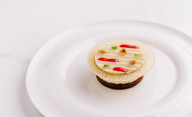 Elegant dessert with layered textures and colorful decorations on a white plate