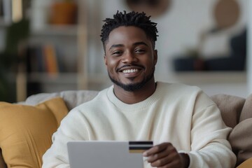 Portrait of a young happy African-American man sitting on the couch at home in front of a laptop, holding a credit card, and smiling at the camera, symbolizing happiness from financial, Generative AI