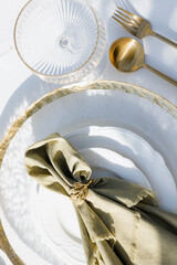 Elegantly set table for a cozy gathering featuring gold-tone cutlery and a textured napkin