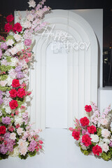 Charming flower-adorned archway for a joyful birthday celebration set in a festive venue with vibrant decorations