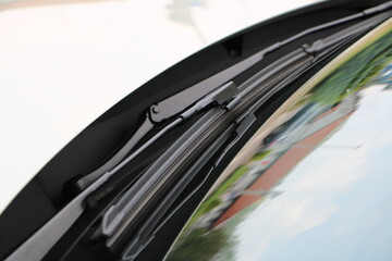 Windshield wiper close-up on curved glass Detailed view of a modern flat-blade windshield wiper...