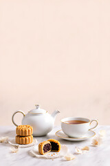 Fototapeta premium Beautiful mooncakes styled with tea set and subtle decorative elements on smooth surface, soft pastel background, clear 