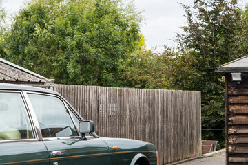 Close-up of the roof of a classic green vintage car and hut.