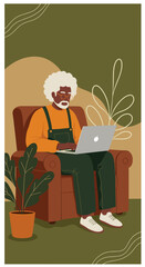 Senior Black man with glasses using a laptop comfortably in an armchair at home. Represents remote work, online learning, or modern digital lifestyle for older adults.
