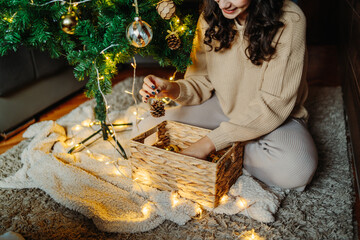 Young caucasian woman putting Christmas decoration on Christmas tree	
