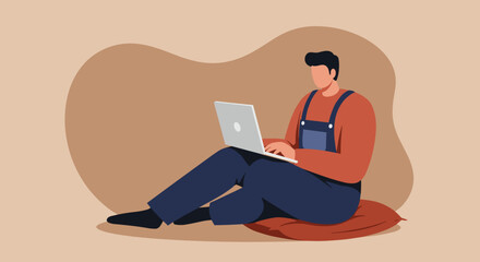 Young man in overalls sitting comfortably on a cushion, focused on his laptop, depicting remote work, casual computing, or online learning.