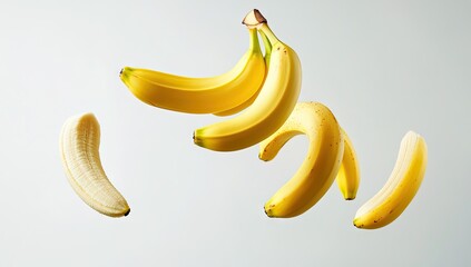 Yellow bananas in mid-air, some peeled