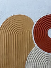 A close-up of a handmade textured 3D abstract painting with raised curved lines in orange, beige,...