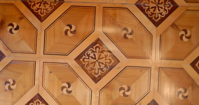 Trieste, Italy &mdash; reverse rotation across an ornate parquet floor with geometric inlays and floral medallions inside a historic palazzo, warm wood textures and refined heritage design