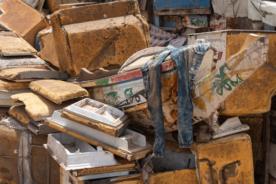 Dakar, Senegal - 12 May 2025: View of discarded debris and refuse, with a pair of blue jeans draped amongst the textured, weathered forms at Plage de Soumb&Atilde;&copy;dioune.