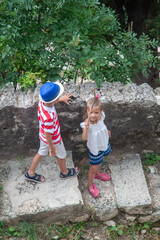 Captivating overhead shot of two playful young children, boy and girl, exploring weathered stone...