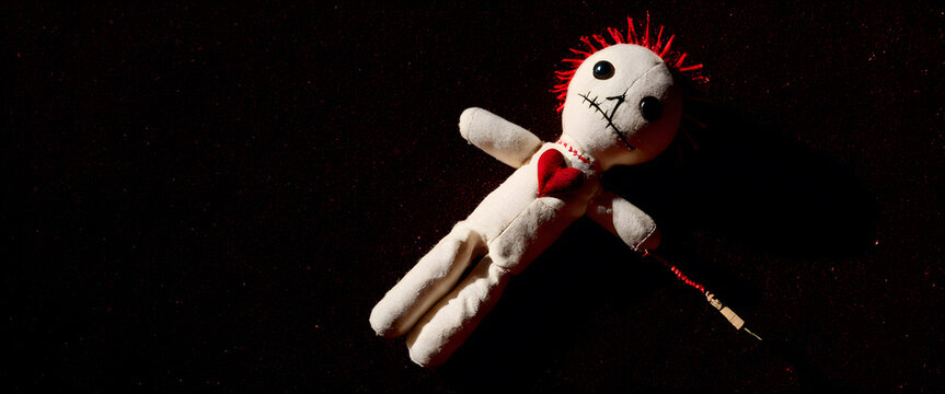 Creepy rag doll with red hair and heart ornament. Haunted cursed doll lying alone on the floor. Scary rag doll fallen on the ground.
