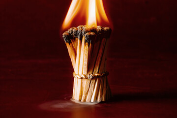 Wedding ring holding burning matches, dramatic symbol of broken marriage, passion, divorce, or...