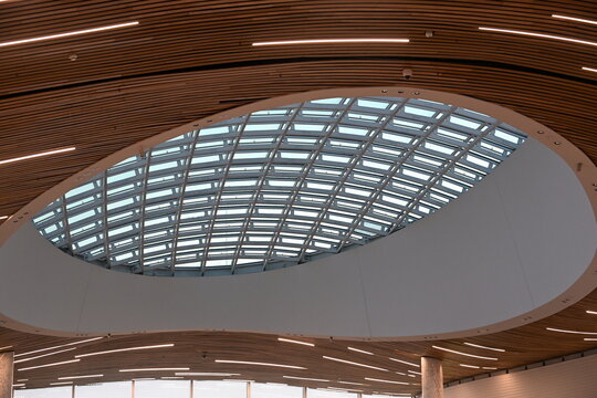 Interesting modern steel and wood ceiling in a shopping mall with windows
