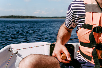 Man tourist steering wooden sailboat on pond Lake Ladoga in Karelia, Russia