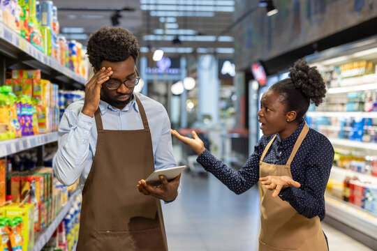 Tense discussion between supermarket staff in aisle amid inventory concerns